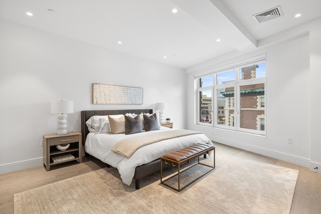 69 Walnut Street, Unit 10A Brookline, MA 02445 - Photo 10 of 17 a bed sitting in a spacious bedroom next to a window