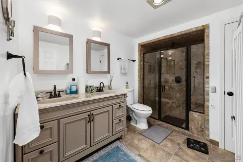 a spacious bathroom with a granite countertop sink toilet and shower