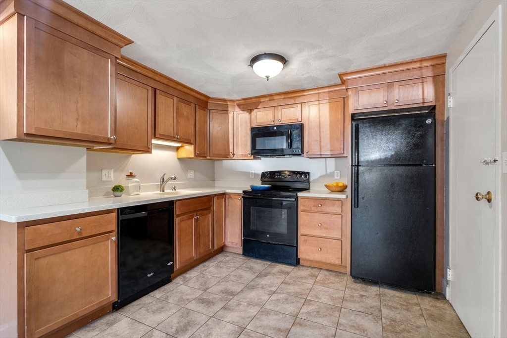 1105 Lexington Street, Unit 41 Waltham, MA 02452 - Photo 2 of 9 a kitchen with a sink stove and refrigerator