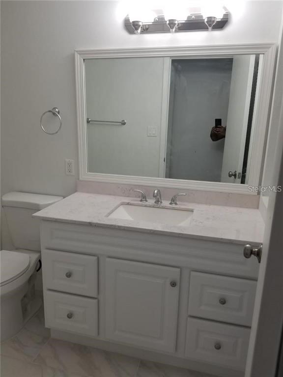 236 Afton Square, Unit 201 Altamonte Springs, FL 32714 - Photo 20 of 42 a bathroom with a sink a toilet and mirror