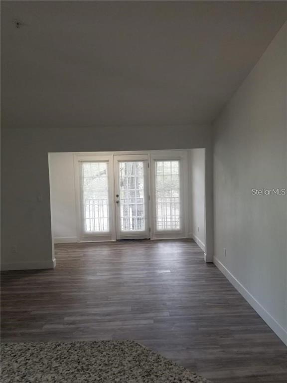 236 Afton Square, Unit 201 Altamonte Springs, FL 32714 - Photo 4 of 42 a view of an empty room with wooden floor and a window