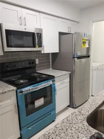 a kitchen with a refrigerator stove and microwave