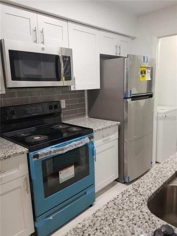 236 Afton Square, Unit 201 Altamonte Springs, FL 32714 - Photo 7 of 42 a kitchen with a refrigerator stove and microwave