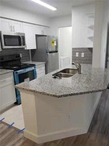 a kitchen with granite countertop a sink and steel stainless steel appliances