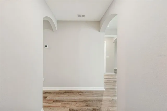 an empty room with a window and a ceiling fan