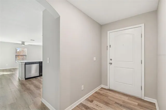 a view of a room with wooden floor and a ceiling fan