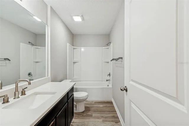 a white toilet sitting next to a white wall