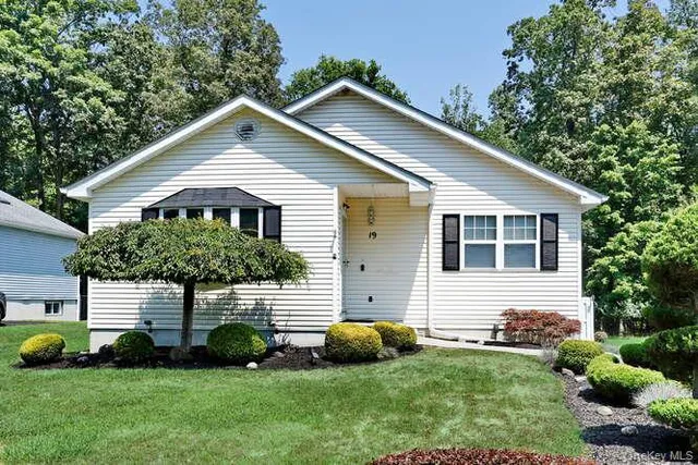 a front view of a house with a garden