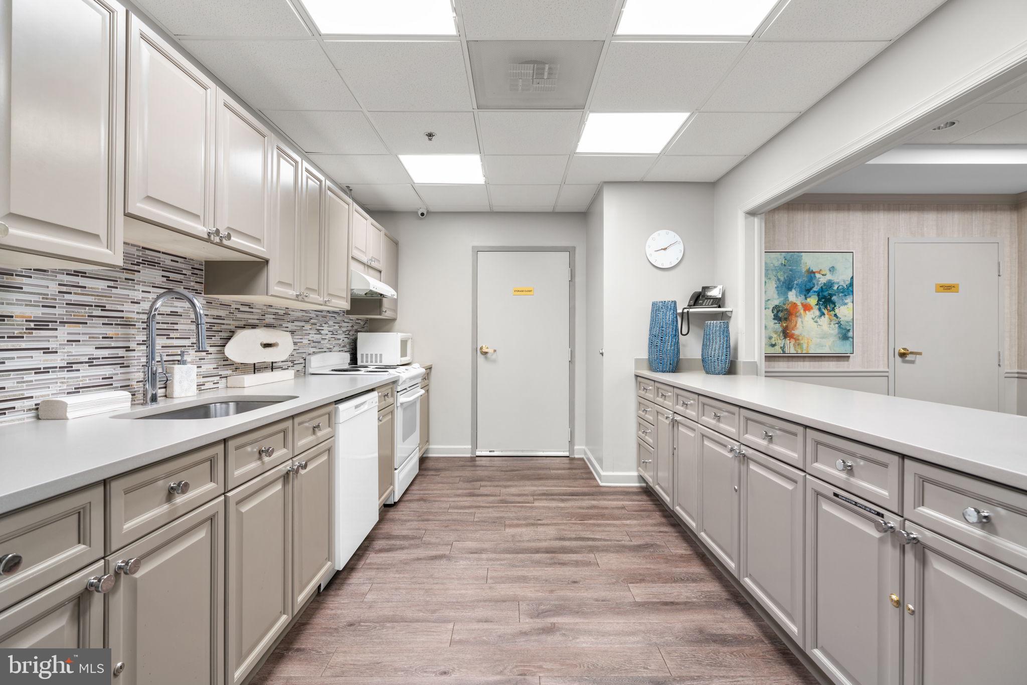 2901 South Leisure World Boulevard, Unit 233 Silver Spring, MD 20906 - Photo 32 of 44 a large white kitchen with lots of counter space and a sink