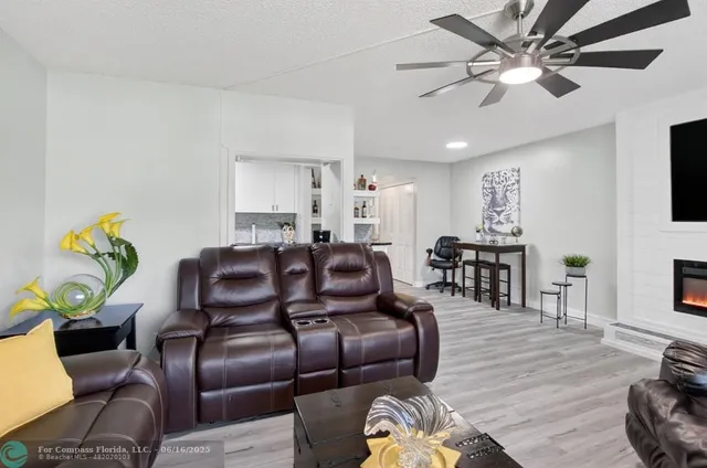 a living room with furniture and a refrigerator