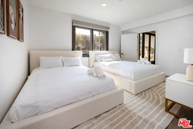 a bedroom with two beds and a large window