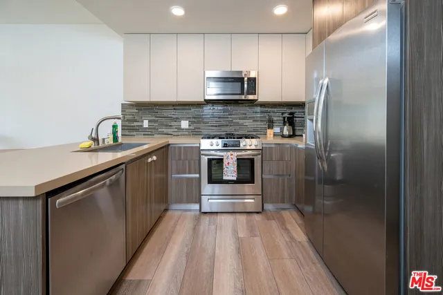 a kitchen with stainless steel appliances granite countertop a stove a sink and a refrigerator