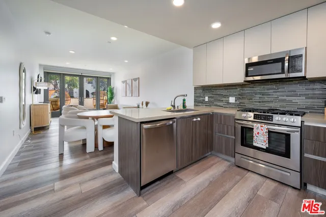 a kitchen with stainless steel appliances kitchen island granite countertop a stove a sink and a microwave