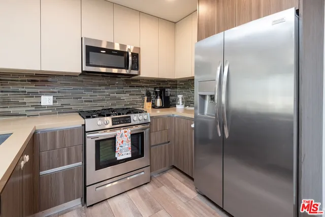 a kitchen with stainless steel appliances granite countertop a stove a refrigerator and a microwave