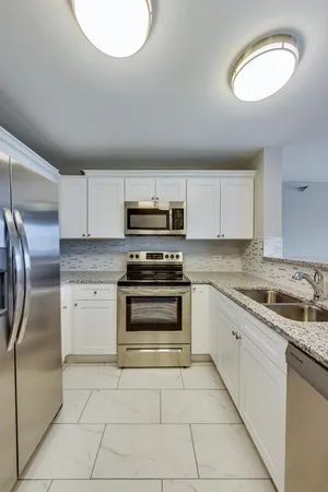 a kitchen with stainless steel appliances granite countertop a stove sink and cabinets