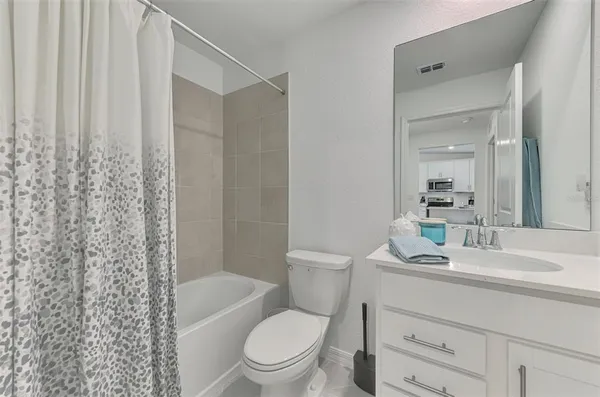 a bathroom with a sink a toilet a mirror and shower