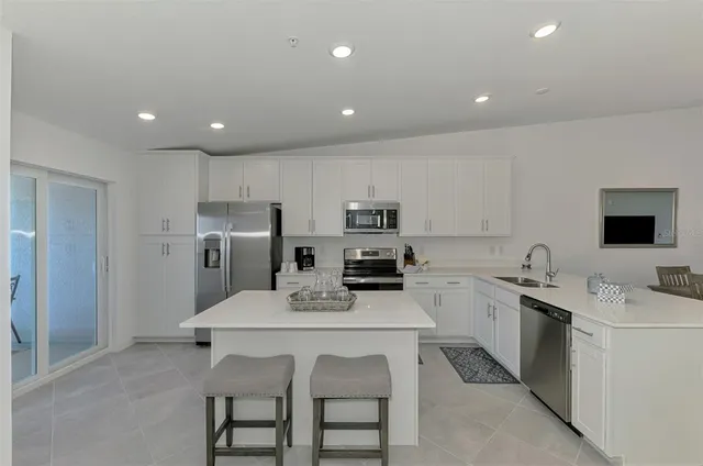 a kitchen with stainless steel appliances a sink stove and refrigerator