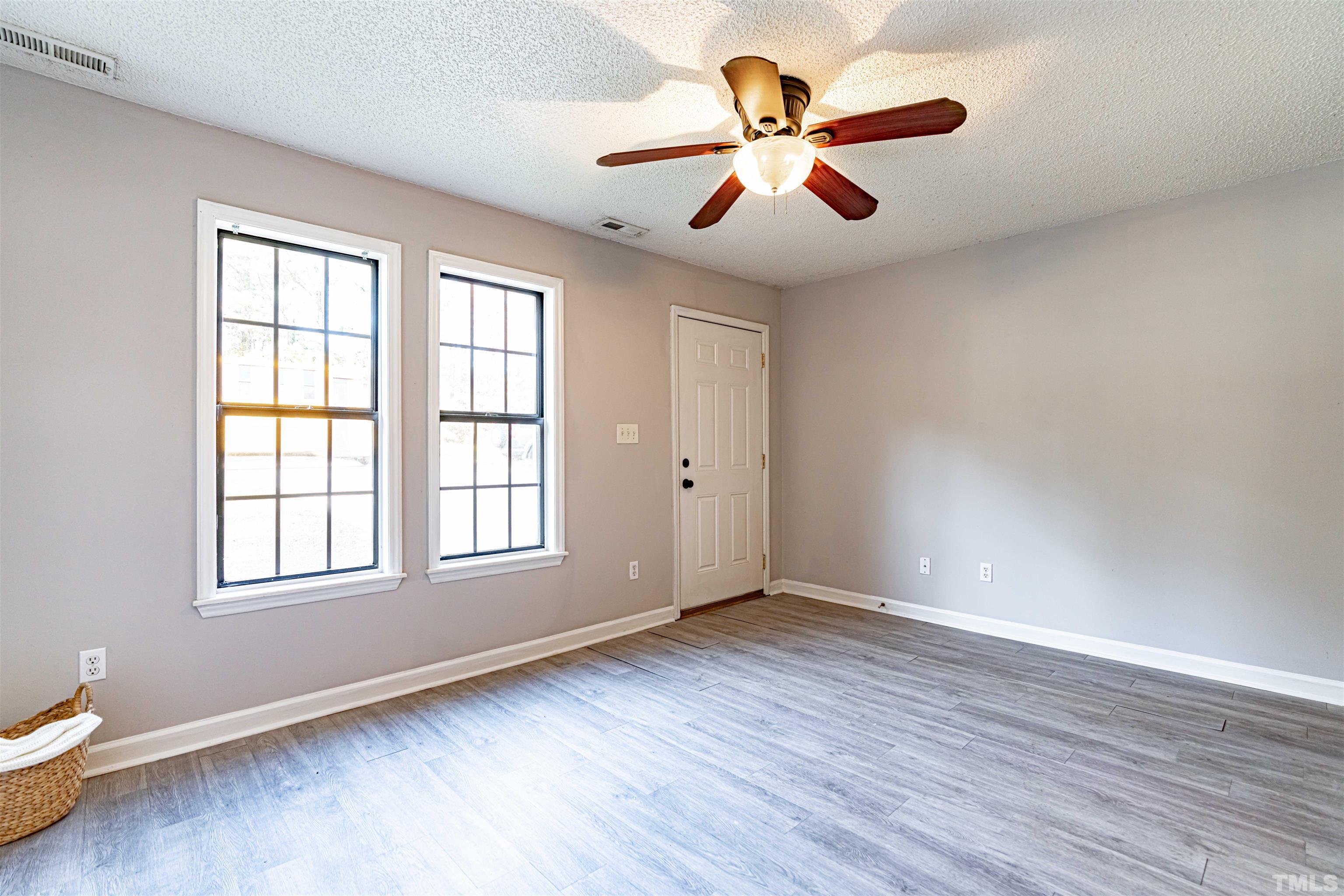 1722 Fox Hollow Drive Raleigh, NC 27610 - Photo 2 of 18 an empty room with wooden floor fan and windows