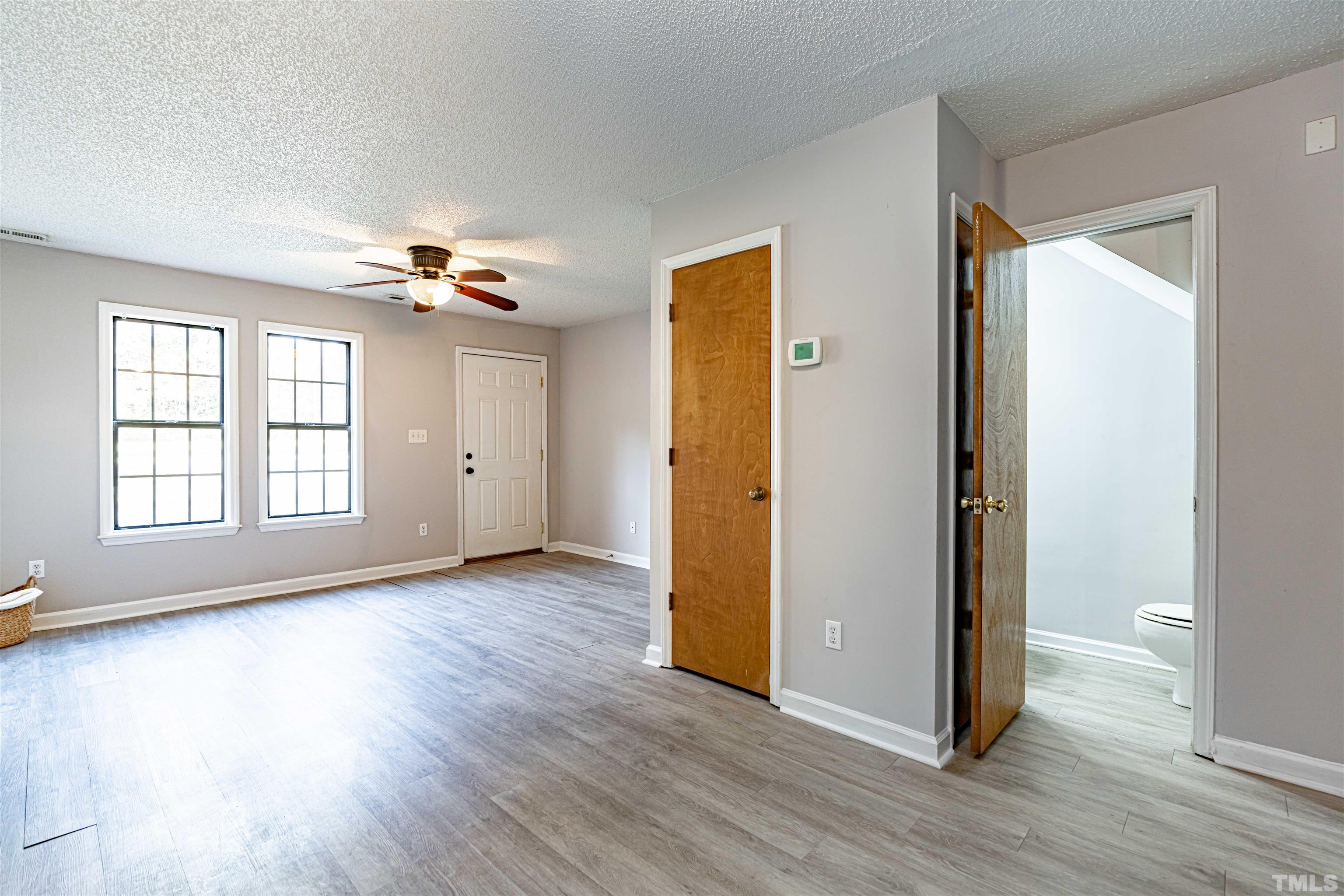 1722 Fox Hollow Drive Raleigh, NC 27610 - Photo 5 of 18 an empty room with wooden floor and windows