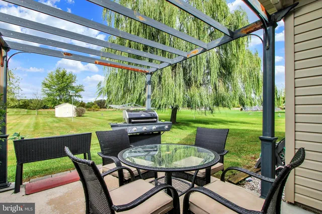 a view of a chairs and table in patio with a yard