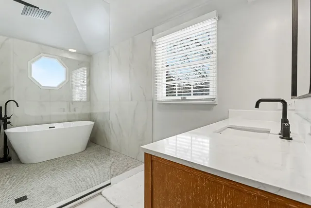 a spacious bathroom with a bathtub sink and window