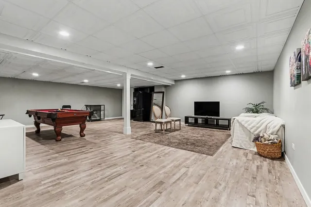 a living room with furniture a flat screen tv and a table