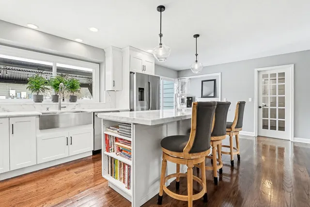 a kitchen with kitchen island a dining table chairs and wooden floor