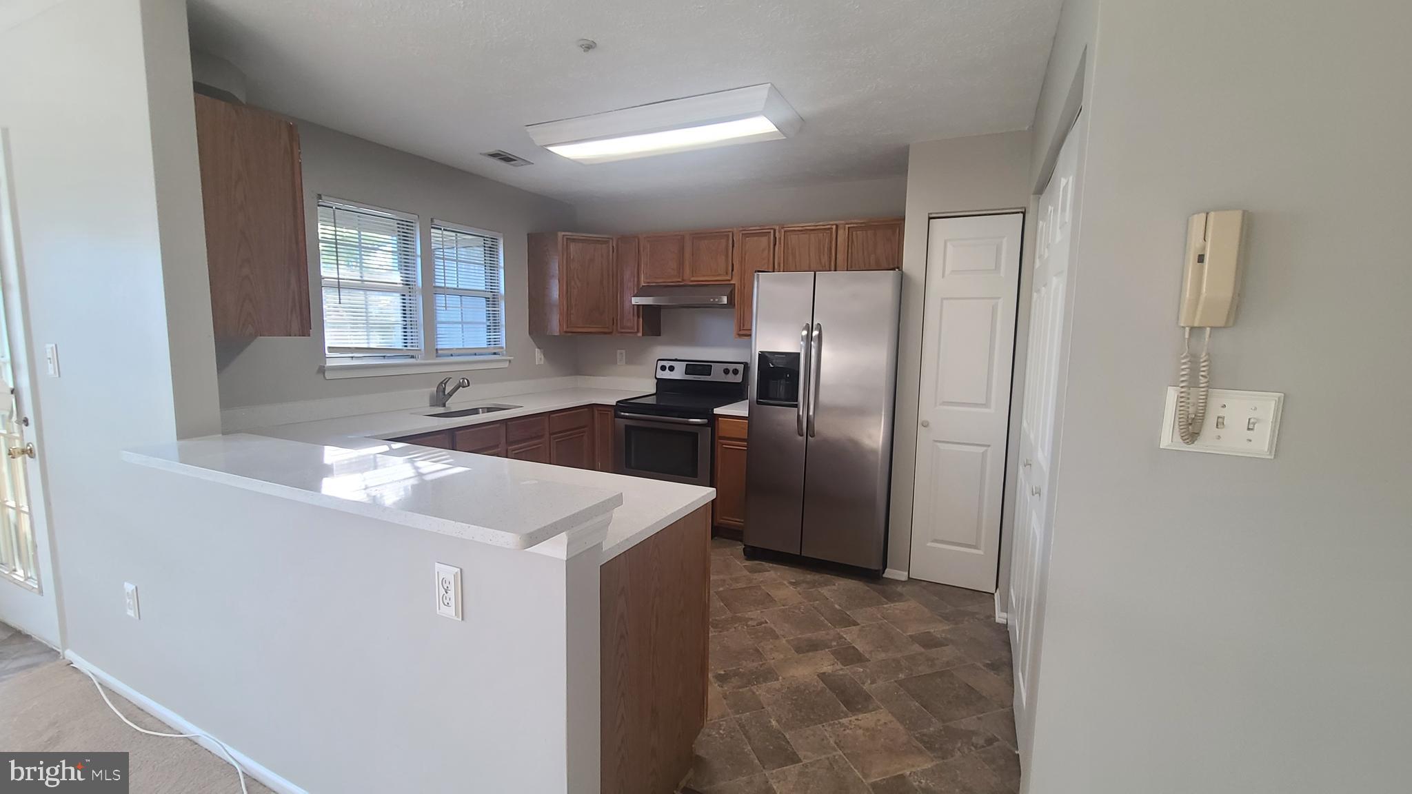 49 Bridle Lane, Unit 55 Nottingham, MD 21236 - Photo 5 of 17 a kitchen with stainless steel appliances granite countertop a refrigerator sink and stove