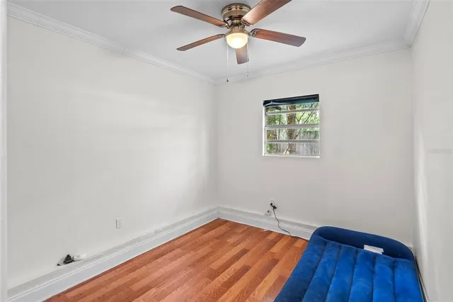 an empty room with a hardwood and ceiling fan