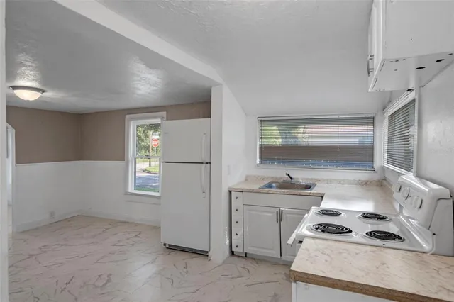 a kitchen that has a sink a stove and window
