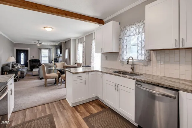 a kitchen with stainless steel appliances granite countertop a refrigerator stove and white cabinets