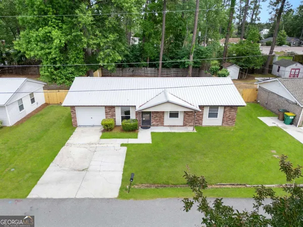 an aerial view of a house with swimming pool garden view and trees