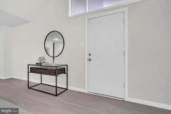 a view of a hallway with wooden floor and white door