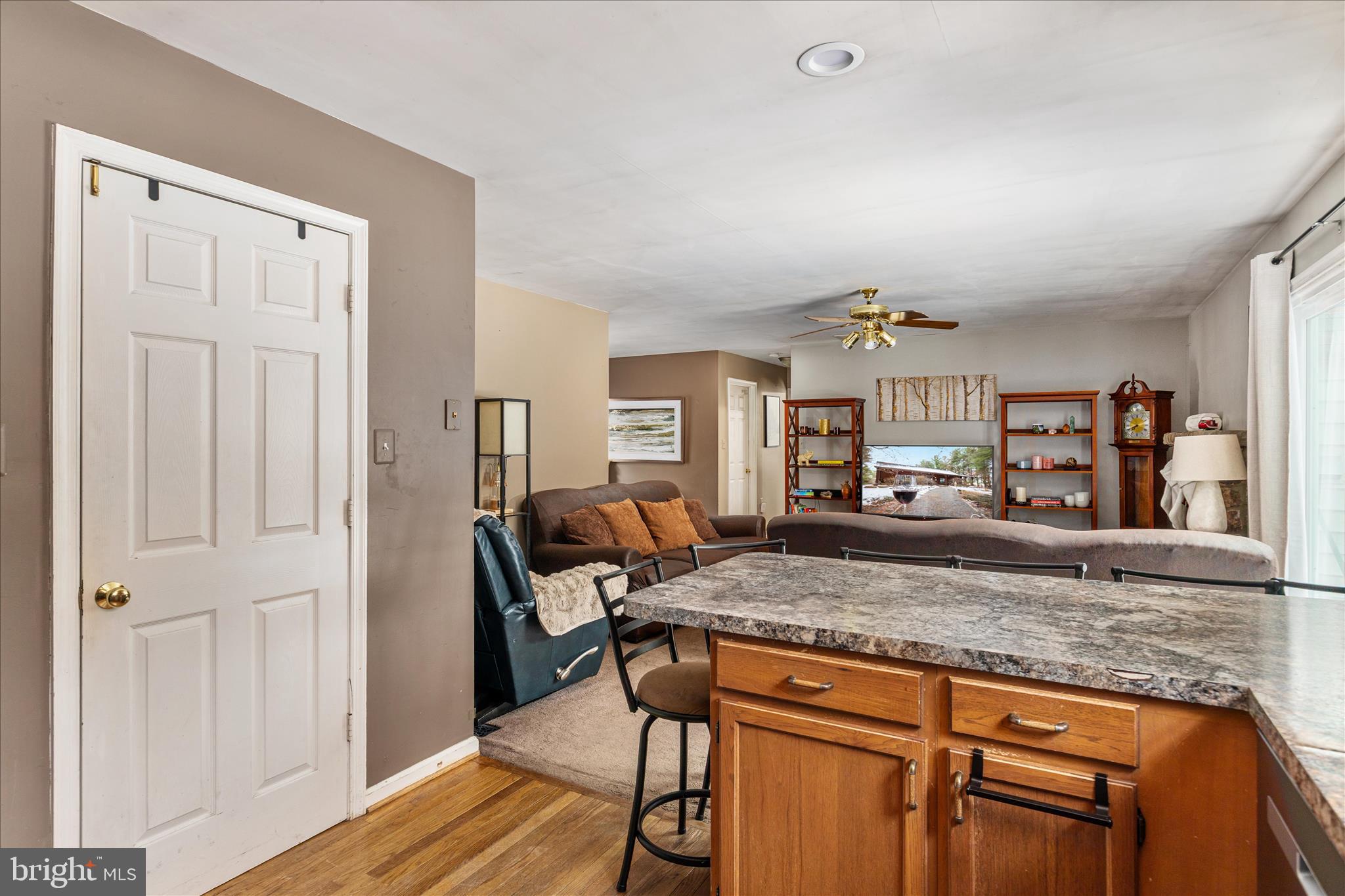 43301 Spinks Ferry Road Leesburg, VA 20176 - Photo 45 of 102 a living room with kitchen island granite countertop furniture and wooden floor