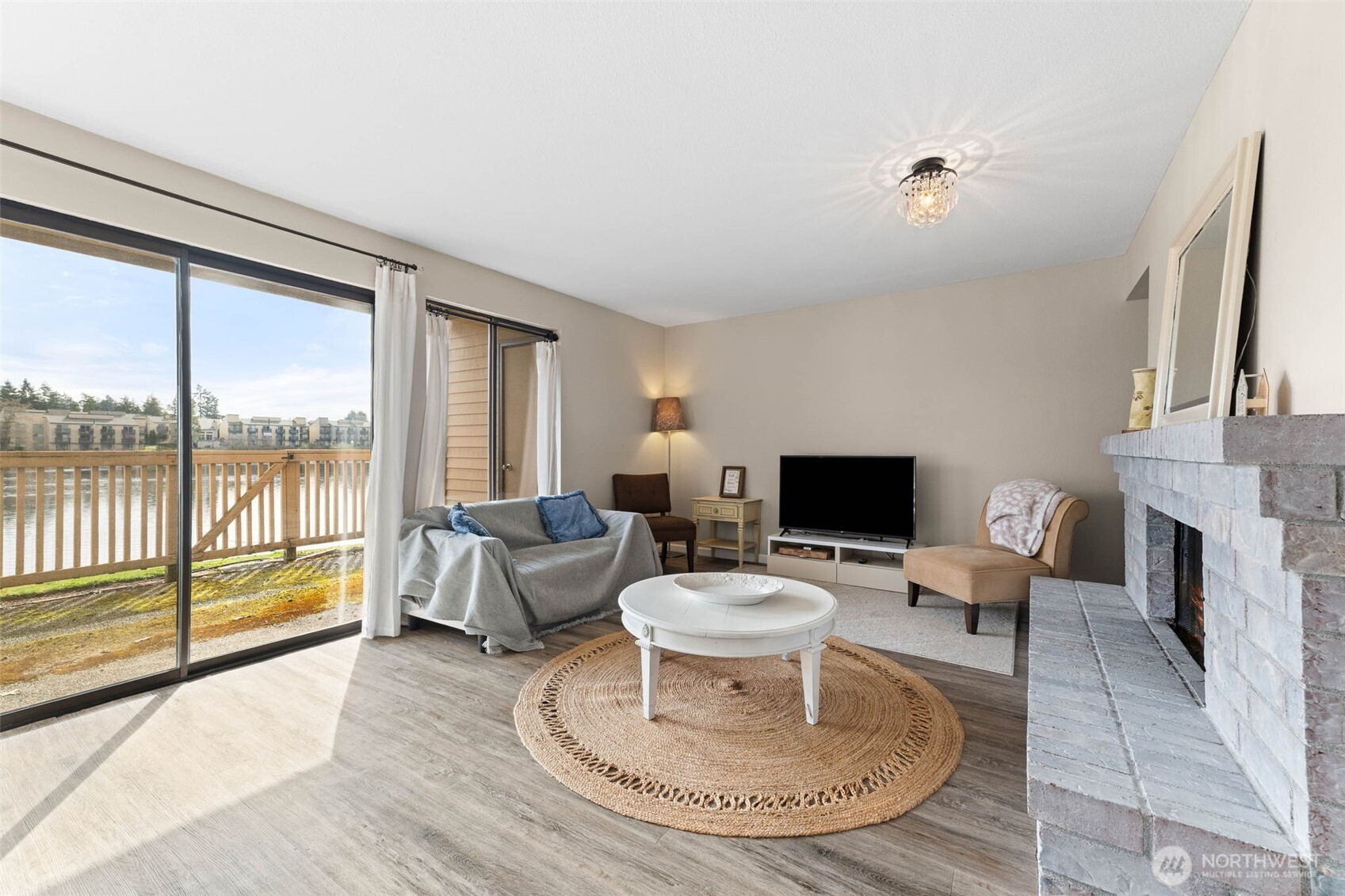1002 South 312th Street, Unit 114 Federal Way, WA 98003 - Photo 2 of 39 a living room with furniture a fireplace and a flat screen tv