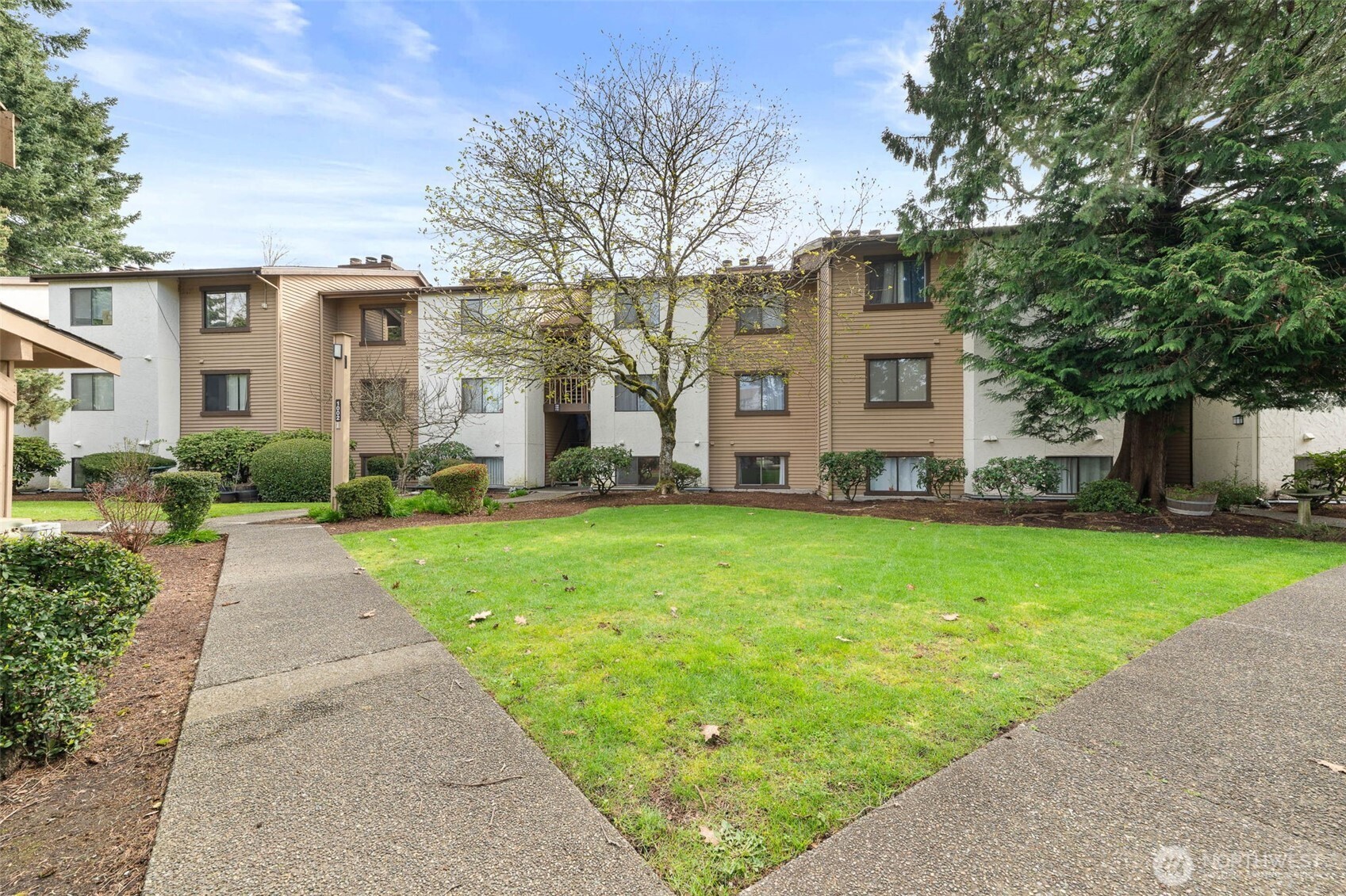 1002 South 312th Street, Unit 114 Federal Way, WA 98003 - Photo 36 of 39 a front view of a house with a garden and plants