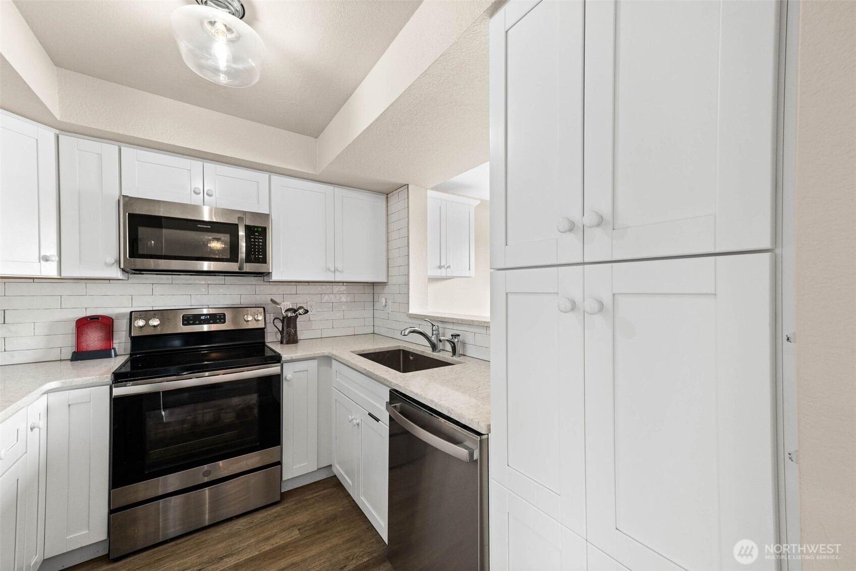 1002 South 312th Street, Unit 114 Federal Way, WA 98003 - Photo 7 of 39 a kitchen with stainless steel appliances granite countertop white cabinets a stove top oven a sink and dishwasher