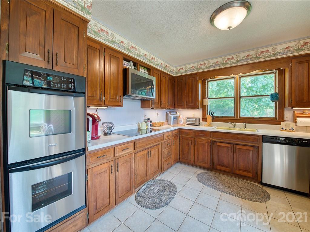 120 Arrowood Acres Road Clyde, NC 28721 - Photo 18 of 42 a kitchen with a sink window and cabinets