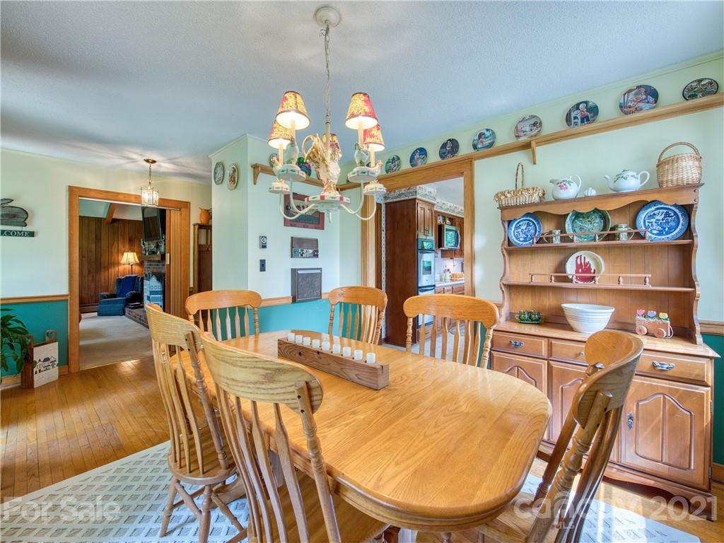 120 Arrowood Acres Road Clyde, NC 28721 - Photo 23 of 42 a view of a dining room with furniture a chandelier and wooden floor