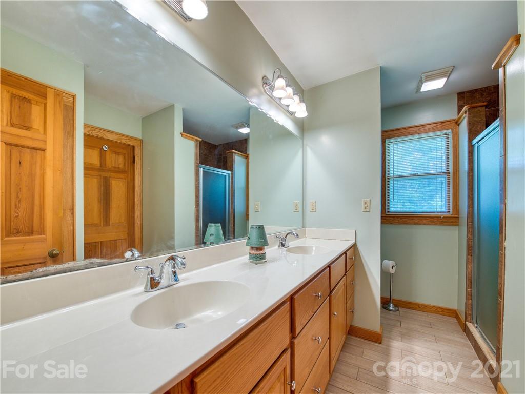 120 Arrowood Acres Road Clyde, NC 28721 - Photo 30 of 42 a bathroom with a double vanity sink and a mirror