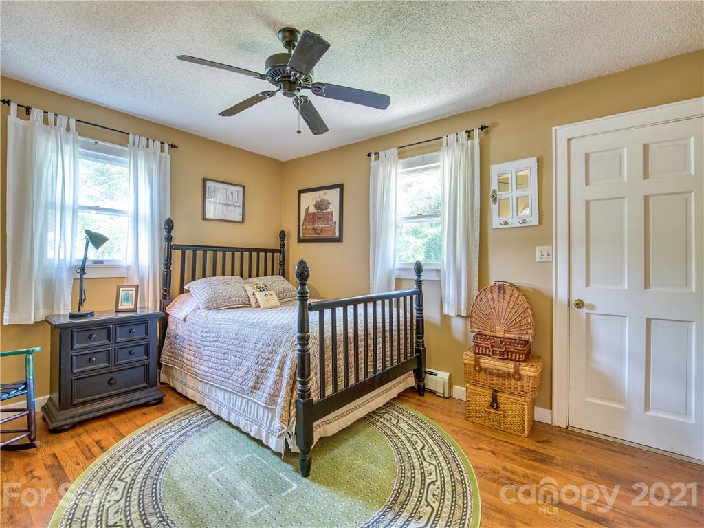 120 Arrowood Acres Road Clyde, NC 28721 - Photo 31 of 42 a bedroom with a bed and wooden floor