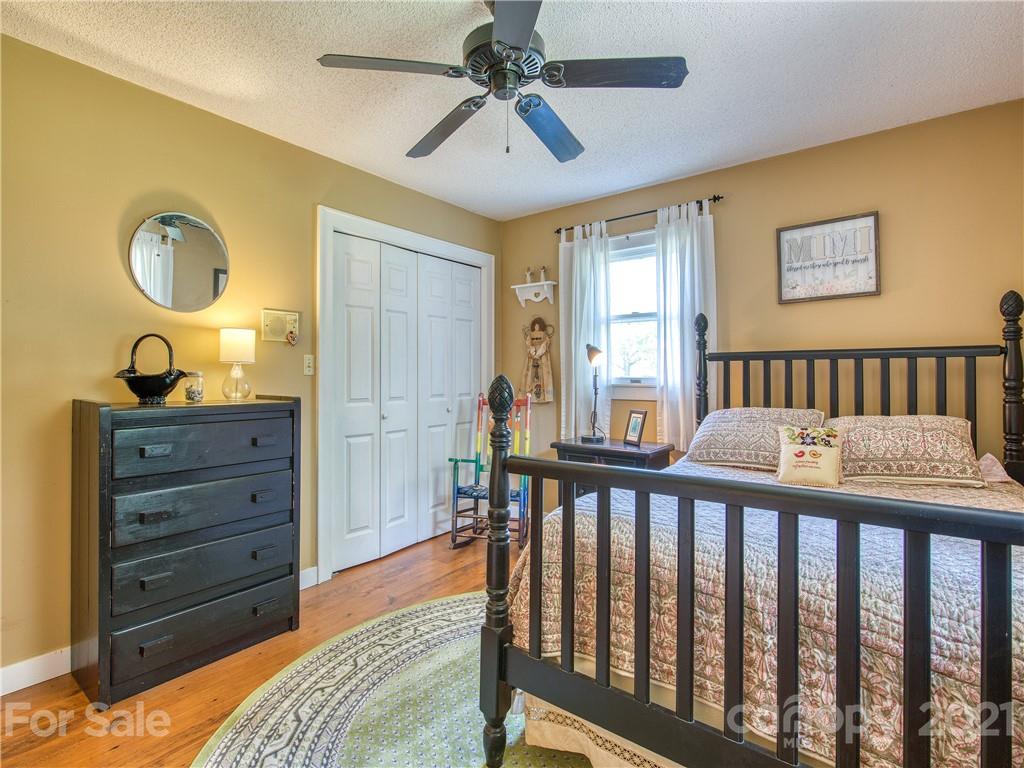 120 Arrowood Acres Road Clyde, NC 28721 - Photo 32 of 42 a view of a bedroom with furniture window and wooden floor