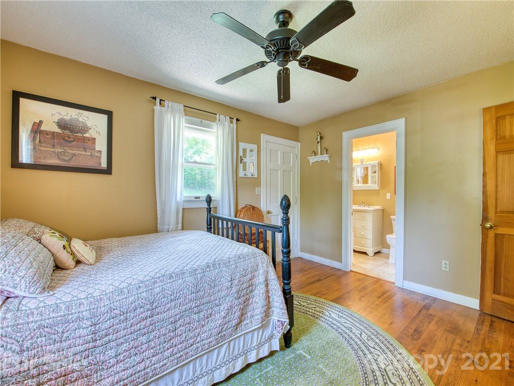 120 Arrowood Acres Road Clyde, NC 28721 - Photo 33 of 42 a bedroom with a bed and a large window with a flat tv screen