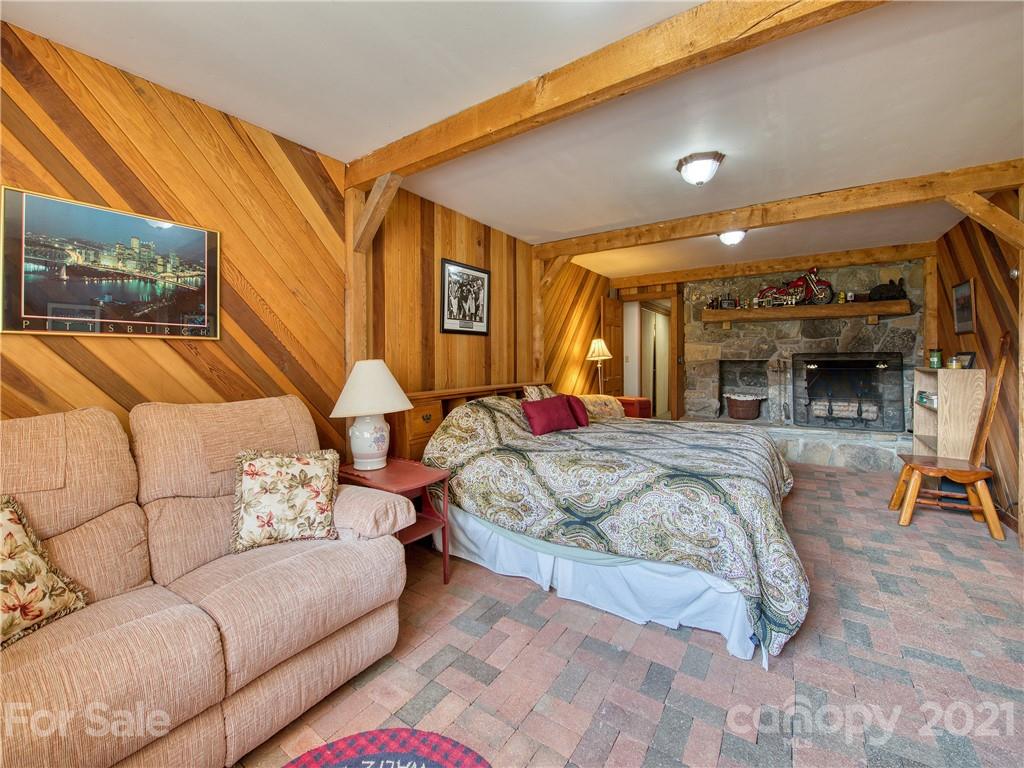 120 Arrowood Acres Road Clyde, NC 28721 - Photo 38 of 42 a bedroom with furniture and a fireplace
