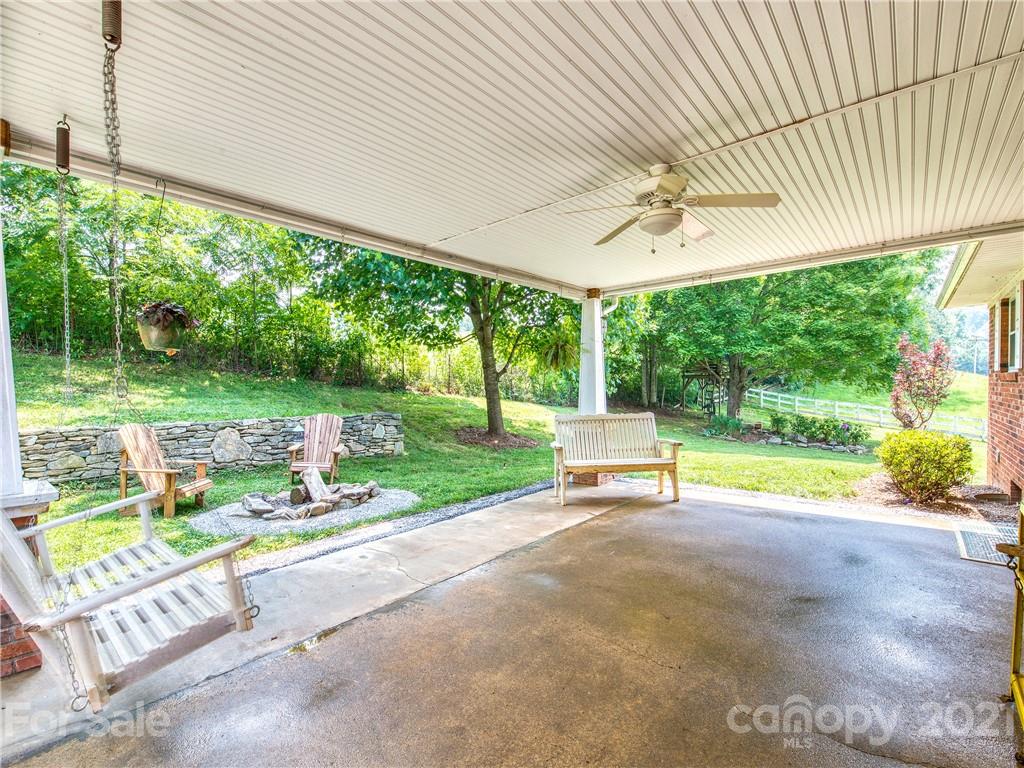 120 Arrowood Acres Road Clyde, NC 28721 - Photo 6 of 42 a view of backyard with a table and chairs and floor to ceiling window