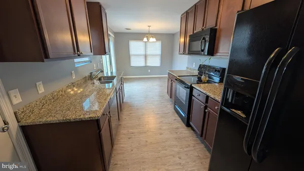a kitchen with sink stove and refrigerator