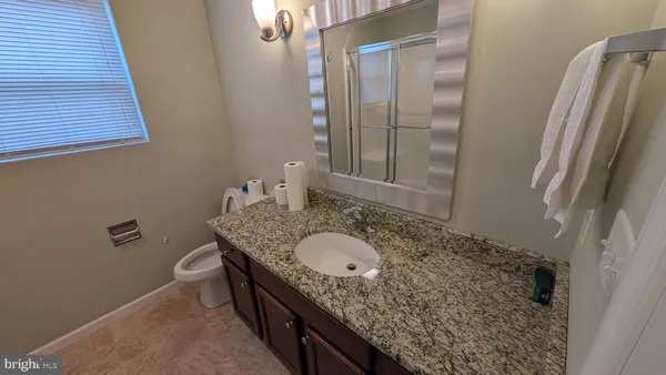 a bathroom with a granite countertop sink and a mirror