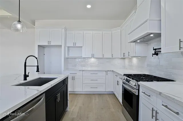 a kitchen with granite countertop a sink stainless steel appliances and cabinets