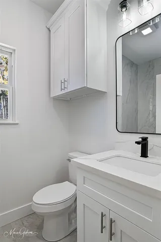 a bathroom with a toilet sink and mirror