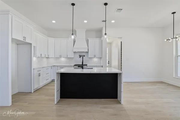 a view of kitchen with stainless steel appliances granite countertop cabinets and a table